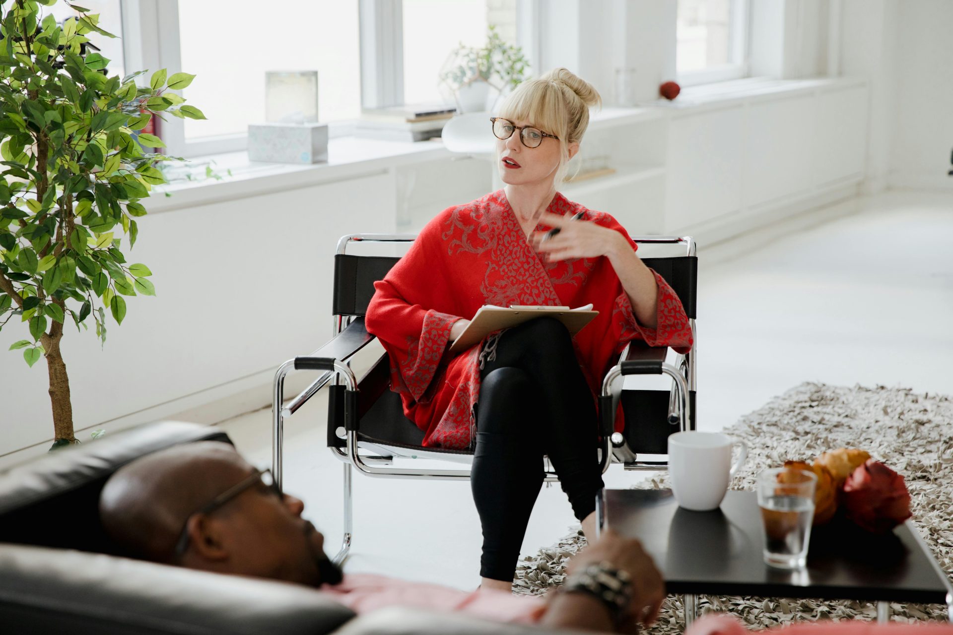 A therapist consults with a patient in a bright, modern office setting.